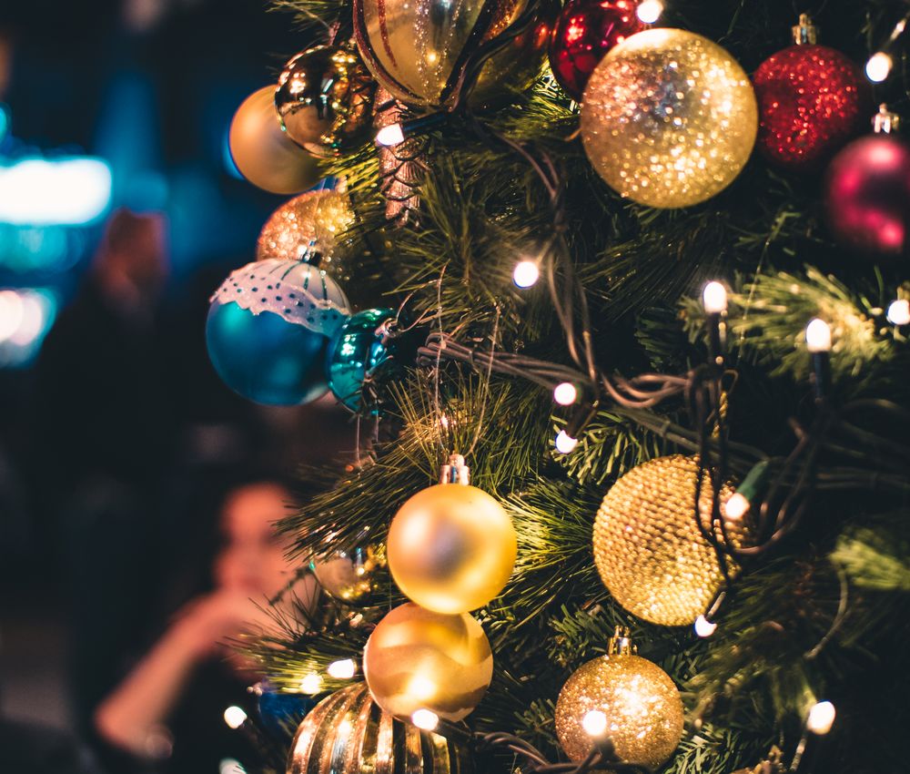 Gold baubles with blue accents on a warmly lit tree